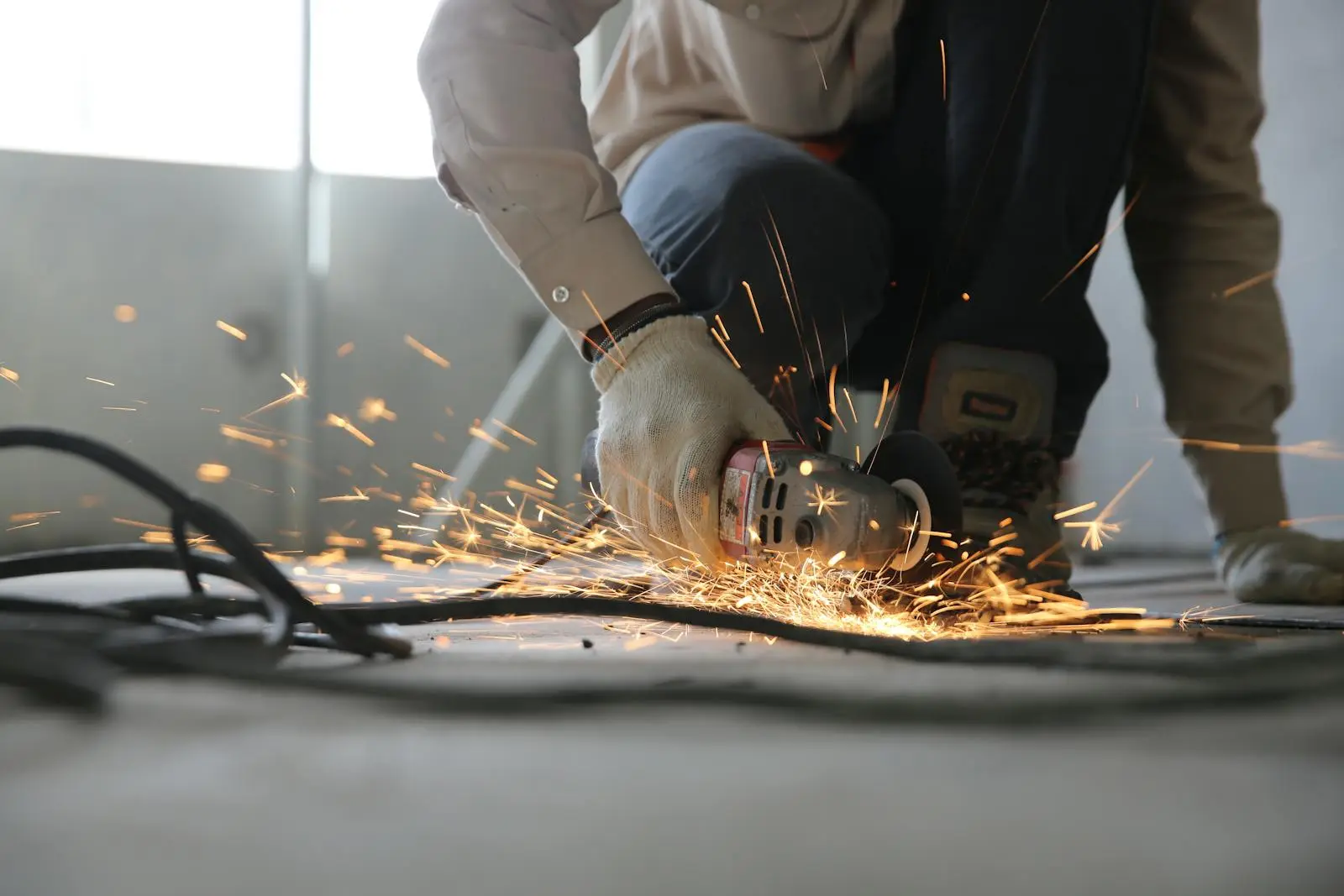 A tradesperson at work on site, sparks from an angle grinder